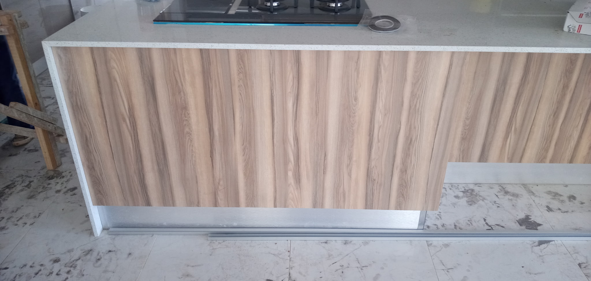 High gloss grey kitchen with white waterfall counter and walnut feature island