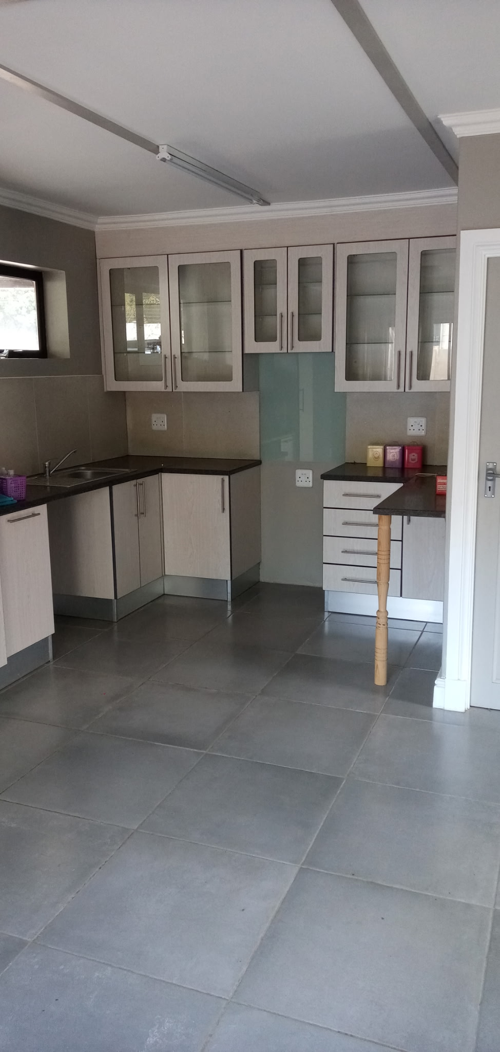 High gloss grey kitchen with walnut feature and white waterfall counter, wide view